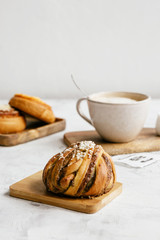 Swedish cinnamon roll and cappuccino on a light background