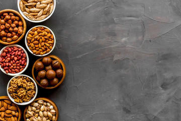 Set of macadamia, hazelnut, walnut, almond, pistachio, pecans nuts on grey background top-down...