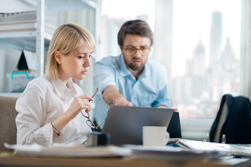 Kind manager giving feedback to young female intern in a busy downtown office. New employee asking...