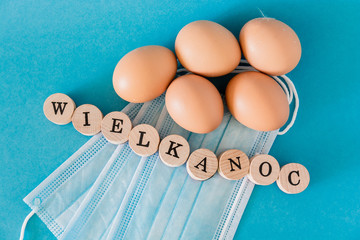Eggs lying on face masks, wooden letters, 
