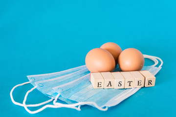 Egg lying on face mask, wooden letters saying easter, sars easter concept studio photo