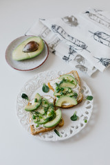 toast with avocado with curd cheese on a white plate