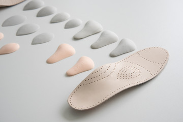 The process of manufacturing individual orthopedic insoles for people with foot diseases, flat feet. Close-up of the insole and accessories for it. - obrazy, fototapety, plakaty