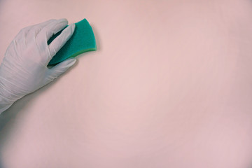 Concept of cleaning. Hand in glove with green sponge.