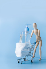 Grocery trolley with disinfecting gel in protective mask. Concept of dangers during Coronavirus pandemic COVID-19.