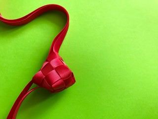 Red Ketupat ribbon on green background