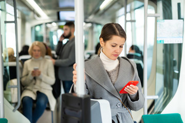Fototapeta na wymiar Brunette with phone in streetcar