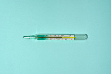 Medical thermometer shows high body temperature 39.9 - 40 celsius. Mercury thermometer flat lay on...