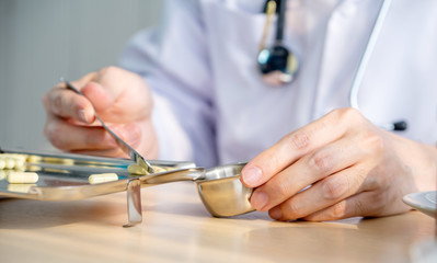 Pharmacist counting pills or medicine in stainless steel containers on the table for dispensing customer or patient, concept Pharmacist in the use of Medical.