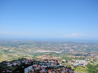 Panoramic view of mountain ranges on the horizon against the backdrop of sunny blue sky covered with lonely clouds.