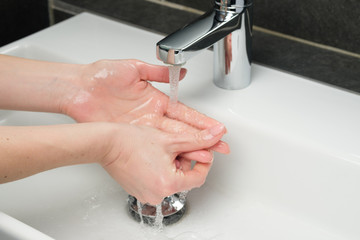 Hygiene concept. Washing hands under the faucet with water