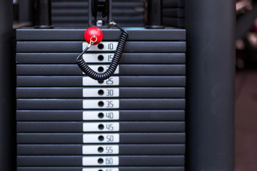 Black iron heavy plates stacked of weight machine in fitness gym. Sports simulator plates