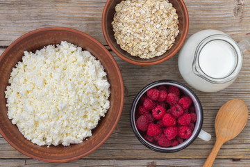 Healthy breakfast items. Oatmeal, milk, fresh berries and cottage cheese. Overhead view, rustic style