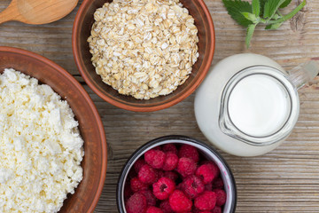 Healthy breakfast items. Oatmeal, milk, fresh berries and cottage cheese. Overhead view, rustic style