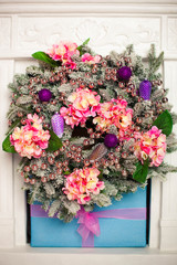 Fototapeta na wymiar cristmas wreath with flowers and beads hanging on the wall