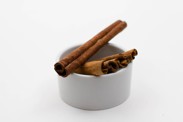Zimtstangen in einer weißen Schale freigestellt