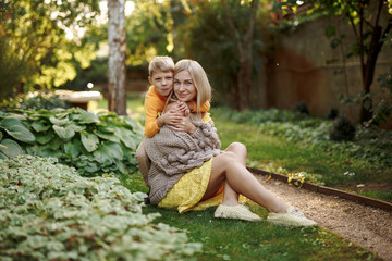 family in nature, summer or autumn, green grass trees in green leaves, a pond in nature, mom blonde in a yellow dress, dad, husband, older son and youngest son, two children, a large and happy family