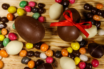 Easter composition with chocolate eggs on wooden background