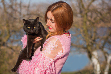 Girl with a black cat outside