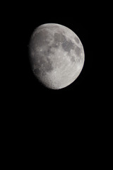 Incomplete moon in the telescope on a black background of the night