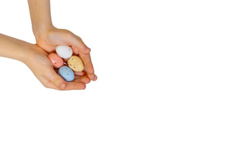 Top view of unrecognizable children making smiley from colorful quail eggs on blue background during Easter celebration