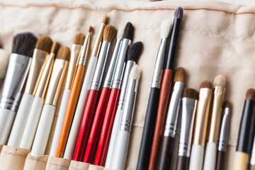 Obraz premium Makeup, beauty and cosmetics concept - Set of make-up brushes in a light case.