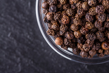 aromatic black pepper on a dark stone background