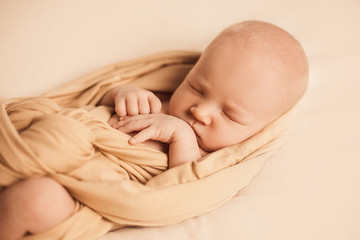 portrait of a newborn baby boy on a beige background