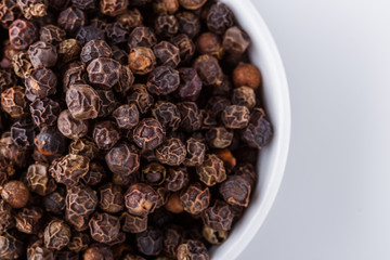 fragrant black pepper on white acrylic background