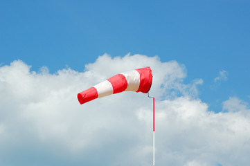 Сolorful professional windsock or windbag, wind direction indicator. durable red and white nylon textile tube mounted on steel ring frame on post. clear blue sky