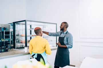 Obraz premium Ethnic waiters in aprons in cafe