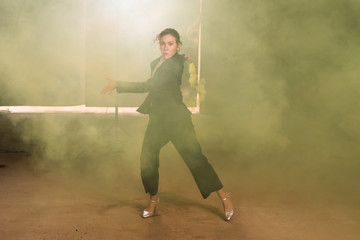 Pasadoble, latin solo dance and contemporary dance - Young beautiful female dancing into smoke cloud