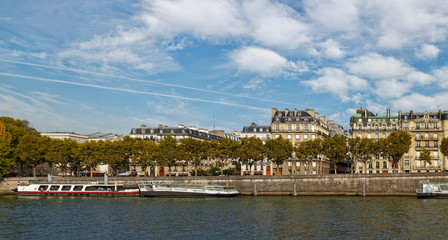 Fototapeta na wymiar Moored River Barges next to the Stone built banks of the River Seine in Central Paris.