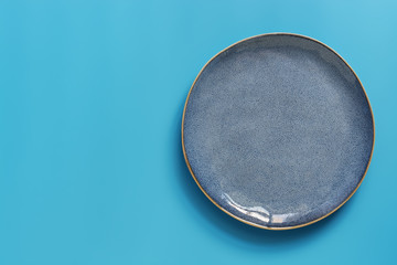 Flat lay empty blue plate on a blue pastel background. Top view, copy space.