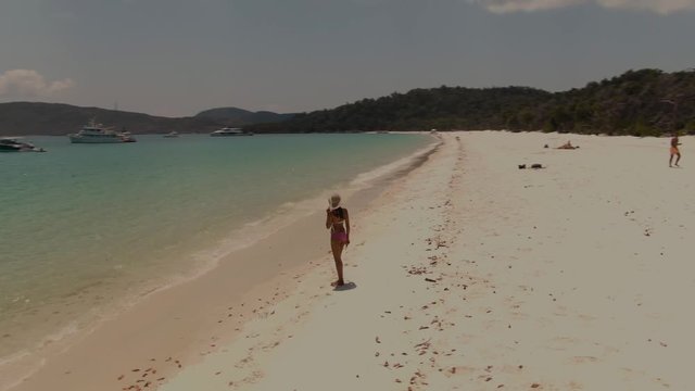 Woman on Beach, Turquoise ocean, white sand DRONE view. Aerial of Whitehaven beach , Whitsundays. Dramatic view. Travel, holiday, vacation, paradise, exotic, romantic, honeymoon. Queenstown Australia