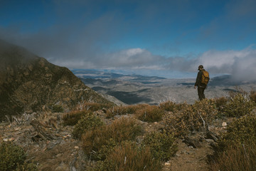 Fototapeta premium man overlooking mountains with blue sky
