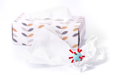 Covid-19 model in front of a box with paper tissues. Coronavirus pandemic theme.