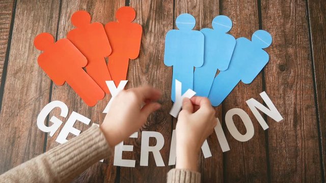 hands makes up a word generation x, y symbol, paper models of people of different nationalities on wooden background