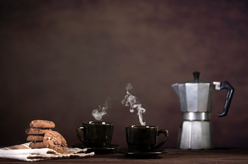 Coffee, cookies and utensils for coffee maker on dark brown background with copy space for text