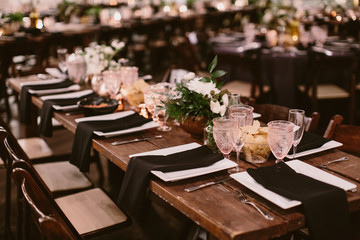 dining table setting with pink drinking glasses and floral centerpieces