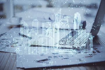 Desktop computer background in office and big town buildings hologram drawing. Double exposure. Smart city concept.