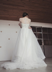 beautiful bride in a lace dress in the Studio. the view from the back