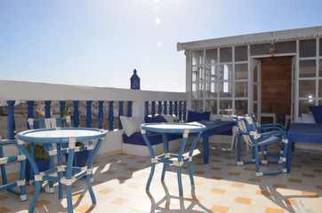 Sunny rooftop with Mediterranean furniture setting at Essaouira. Essaouira is a port city and resort on Morocco’s Atlantic coast.  