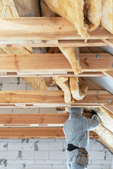 Workman in overalls working with rockwool insulation material