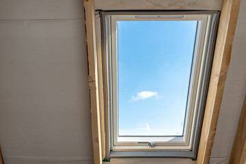 Plastic mansard window with triple glasses and clear view on sky