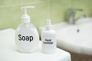 Bottles of liquid soap and hand sanitizer in bathroom