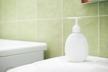 Bottle of liquid soap in sink in the bathroom