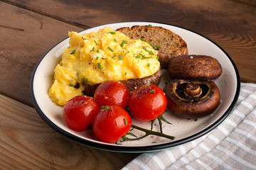 scramble egg with grilled tomatoes and mushrooms. breakfast.