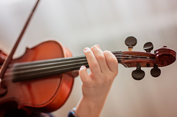 Home lesson for a girl playing the violin. The idea of activities for children during quarantine....