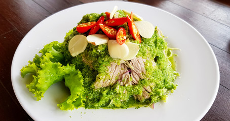 Spicy lime beef salad with chilli and garlic in a white plate